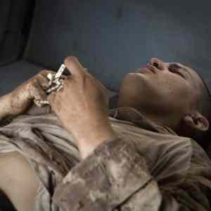 Obrázek 'Foto tyzdna - Afganistan - Raneny americky vojak zviera v ruke ruzenec pocas ...'