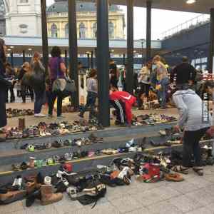 Obrázek 'Hungarians bring their shoes to the Budapest train station for arriving migrants'